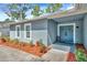 Inviting front entrance with a blue double door, manicured landscaping, and newly mulched flowerbeds at 15718 Gardenside Ln, Tampa, FL 33624