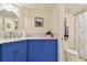 Stylish bathroom with blue vanity, white countertop, and view into toilet and shower at 1600 Gulf Blvd # 817, Clearwater Beach, FL 33767