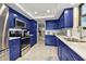 Updated kitchen with stainless steel appliances, marble countertops, and vibrant blue cabinets at 1600 Gulf Blvd # 817, Clearwater Beach, FL 33767