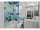 A stylish bathroom featuring turquoise tile accents, glass shower doors, and modern fixtures at 16211 Villarreal De Avila, Tampa, FL 33613