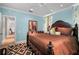 Bedroom with light blue walls, dark wood furniture, and patterned area rug at 16211 Villarreal De Avila, Tampa, FL 33613