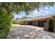 Long driveway leading to a home with a three car garage, stone accents, and manicured landscaping at 16211 Villarreal De Avila, Tampa, FL 33613