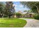 Beautiful home featuring a circular driveway, lush landscaping and mature trees at 16211 Villarreal De Avila, Tampa, FL 33613