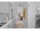 Bright hallway featuring laundry area, mosaic backsplash, and light wood flooring at 16211 Villarreal De Avila, Tampa, FL 33613