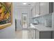 Bright laundry room featuring white cabinets, a sink, and mosaic tile backsplash at 16211 Villarreal De Avila, Tampa, FL 33613