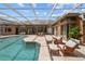 A pool area with travertine tiles, outdoor seating, and a view of the backyard at 16211 Villarreal De Avila, Tampa, FL 33613