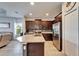 Bright kitchen with stainless steel appliances, granite counters, dark wood cabinetry, and kitchen island at 1806 Lake George Cv, Bradenton, FL 34211