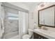 Bathroom featuring tub with marble surround, white vanity, and decorative mirror at 1828 Barbara Ln, Clearwater, FL 33755