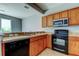 Bright kitchen featuring wood cabinets, stainless sink, and black appliances at 2039 Strathmill Dr, Clearwater, FL 33755