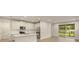 Modern kitchen with stainless steel appliances, island, white cabinets, and a sliding glass door leading to the patio at 20411 Symphony Pl, Venice, FL 34293