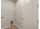 Bright laundry room featuring a wire shelf for storage and a nearby door at 20411 Symphony Pl, Venice, FL 34293