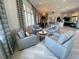 Beautiful lounge area with seating, light-colored floors, and view to kitchen at 20411 Symphony Pl, Venice, FL 34293