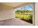 A spacious patio with brick flooring, offering a perfect spot for outdoor relaxation with a view of the manicured lawn at 20411 Symphony Pl, Venice, FL 34293