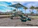 Community playground featuring a covered play structure, slides, and spring rider, perfect for Gathering fun at 20411 Symphony Pl, Venice, FL 34293