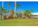 Entrance sign for Harbour Watch waterfront preserve amid lush tropical landscaping and sunny skies at 2053 N Pointe Alexis Dr, Tarpon Springs, FL 34689