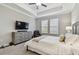 Bright bedroom features a comfy chair, a gray dresser, and a tray ceiling at 21577 Violet Periwinkle Dr, Land O Lakes, FL 34637