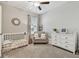 Bedroom featuring neutral paint, carpet, a crib, gray chair, white dresser, and natural light at 21577 Violet Periwinkle Dr, Land O Lakes, FL 34637