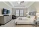 This bedroom features a tray ceiling, neutral walls, and gray furnishings at 21577 Violet Periwinkle Dr, Land O Lakes, FL 34637