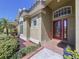 Inviting front entrance with decorative red door, brick walkway, and manicured landscaping at 2204 Margaret Way, Dunedin, FL 34698