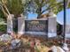 Entrance sign to Highland Woods surrounded by well-manicured greenery and colorful flowers at 2204 Margaret Way, Dunedin, FL 34698