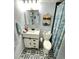 Updated bathroom features a black and white tile floor, white vanity with storage, and stylish seashell shower curtain at 2205 Belleair Rd # A7, Clearwater, FL 33764