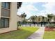 Community pool area with lush palm trees, manicured landscaping, and comfortable seating for residents to enjoy at 2205 Belleair Rd # A7, Clearwater, FL 33764