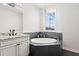 Bathroom with double vanity, granite countertop, and tub under a chandelier at 224 S Audubon Ave, Tampa, FL 33609