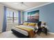 Comfortable bedroom with a ceiling fan, an accent wall, and bright natural light from the window at 224 S Audubon Ave, Tampa, FL 33609