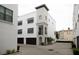 Charming three-story townhouse featuring white stucco, dark wood garage doors, and well-maintained landscaping at 224 S Audubon Ave, Tampa, FL 33609