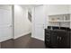 Hallway area featuring a convenient sink, black countertop, and modern dark wood floors at 224 S Audubon Ave, Tampa, FL 33609