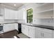 Bright kitchen features white cabinets, black countertops, stainless steel sink and appliances, plus modern fixtures at 224 S Audubon Ave, Tampa, FL 33609
