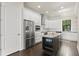 Modern kitchen with stainless steel appliances, white cabinets, and a center island at 224 S Audubon Ave, Tampa, FL 33609