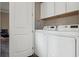 A functional laundry room features a modern washer and dryer with overhead cabinet storage at 224 S Audubon Ave, Tampa, FL 33609