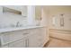 Bathroom with white cabinetry, marble countertops, and stained glass windows above bathtub at 238 Pelican N Dr, Oldsmar, FL 34677