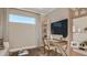 Functional home office space with a built-in desk, shelving, TV, and natural light at 29508 Zupetta Ln, Wesley Chapel, FL 33543