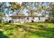 A white house with a lawn and screened in porch is ready for new owners at 3005 E Sligh Ave, Tampa, FL 33610