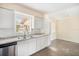 Bright kitchen featuring sleek white cabinetry, stainless steel appliances, and ample counter space at 3005 E Sligh Ave, Tampa, FL 33610