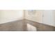 Neutrally painted living room featuring a large window, polished concrete flooring, and a white entry door at 3005 E Sligh Ave, Tampa, FL 33610