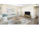 Bright living room featuring a comfortable white sofa, stylish rug, and natural light from the window at 3005 E Sligh Ave, Tampa, FL 33610