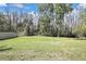 Expansive green backyard bordered by tall trees with a white fence at 3033 Marble Crest Dr, Land O Lakes, FL 34638