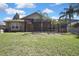 Picture of the backyard, which features a screened-in lanai overlooking the grass and palm trees at 3033 Marble Crest Dr, Land O Lakes, FL 34638