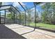 Spacious screened-in patio with brick pavers and a large backyard with tropical landscaping at 3033 Marble Crest Dr, Land O Lakes, FL 34638