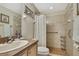 Bright bathroom with ceramic tile shower and floors, wood cabinets and grab bar at 3033 Marble Crest Dr, Land O Lakes, FL 34638