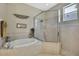 Well-lit bathroom featuring a soaking tub and separate glass-enclosed shower with a modern design at 3033 Marble Crest Dr, Land O Lakes, FL 34638