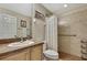Bright bathroom with ceramic tile shower and floors, wood cabinets and grab bar at 3033 Marble Crest Dr, Land O Lakes, FL 34638