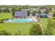 Aerial view of a community pool, a playground, and surrounding green spaces in a residential neighborhood at 3033 Marble Crest Dr, Land O Lakes, FL 34638