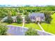 Stunning stone clubhouse with lush landscaping, a tennis court, and pool overlooking a picturesque lake at 3033 Marble Crest Dr, Land O Lakes, FL 34638