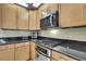 Updated kitchen with stainless gas range, microwave, oven and black granite countertops at 3033 Marble Crest Dr, Land O Lakes, FL 34638