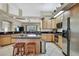 Modern kitchen with a central island, stainless steel appliances, and tiled floor at 3033 Marble Crest Dr, Land O Lakes, FL 34638
