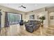 Bright living room with hardwood floors, a comfortable sofa and sliding door to the screened porch at 3033 Marble Crest Dr, Land O Lakes, FL 34638